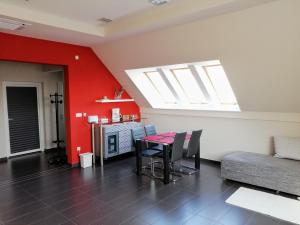 a living room with a table and a red wall at Szépségpatika Apartman in Sárospatak