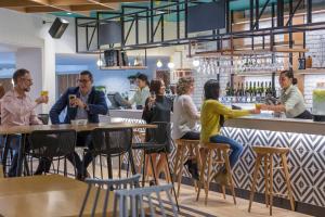 a group of people sitting at a bar at Holiday Inn Auckland Airport by IHG in Auckland