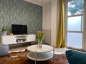 a living room with a vase of flowers on a table at Maison de ville de 55m2 refait à neuf in Verneuil d'Avre et d'Iton