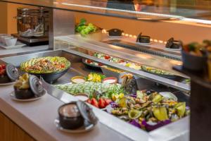a buffet line with many different types of food at Holiday Inn Auckland Airport by IHG in Auckland