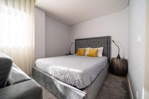 um quarto com uma cama grande e almofadas amarelas em Bracara Guest House "Campo das Hortas" em Braga