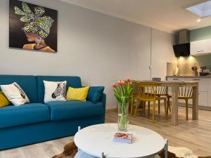 a living room with a blue couch and a table at Maison de ville de 55m2 refait à neuf in Verneuil d'Avre et d'Iton