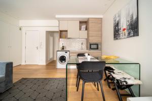 a kitchen with a glass table and chairs at Bracara Guest House "Campo das Hortas" in Braga