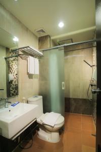 a bathroom with a toilet and a sink and a shower at Transera Hotel Pontianak in Pontianak