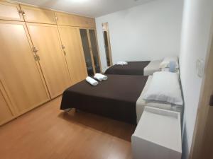 um pequeno quarto com 2 camas e um closet em Alojamiento a 6 min de aeropuerto e ifema y cerca de wanda metropolitano em Madri