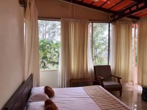 a bedroom with a bed and a chair and a window at LAZY DAYS Wayanad in Cherambādi +42 photos