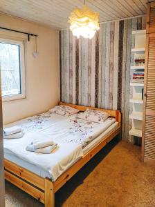 a bedroom with a large bed with white sheets at Dom letniskowy Bory Tucholskie in Osiek