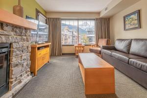 sala de estar con sofá y chimenea en Copperstone Resort - Mountain View 2 Bedroom Condo en Canmore