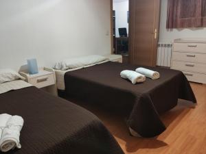 duas camas num quarto com duas toalhas em Alojamiento a 6 min de aeropuerto e ifema y cerca de wanda metropolitano em Madri