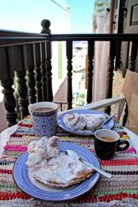 una mesa con dos platos de comida y dos tazas de café en Muse Neate, en Halki