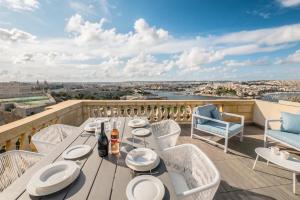 a table on a balcony with a view of the city at Valletta Hastings Suites in Valletta