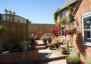 a garden with potted plants on a brick building at Catesby Barn Farm B&B in Daventry