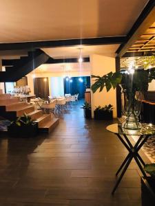a restaurant with tables and chairs and a room with plants at HOTEL CASA MAYOR LA 70 in Medellín +12 photos
