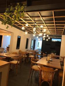 un restaurante con mesas de madera, sillas y luces en HOTEL CASA MAYOR LA 70 en Medellín