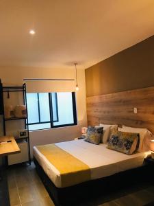a bedroom with a large bed and a window at HOTEL CASA MAYOR LA 70 in Medellín
