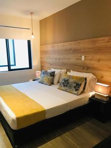 a bedroom with a large bed with a wooden headboard at HOTEL CASA MAYOR LA 70 in Medellín