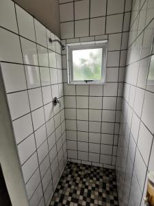 a bathroom with a window and a tiled shower at Happy Forest B&B in Katima Mulilo