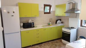 a kitchen with lime green cabinets and a white refrigerator at Casa Arina in Sulina