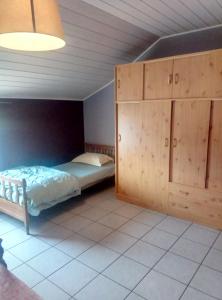 - une chambre avec un lit et une armoire en bois dans l'établissement Gite à la Ferme, à Rouvroy