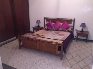 a bedroom with a large bed with purple pillows at Villa Tazi in Meknès
