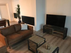 uma sala de estar com um sofá e uma televisão de ecrã plano em VAKANTIE WONING OASE em Breskens