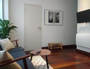 uma sala de estar com um sofá e uma mesa em Appartement rénové 2 chambres centre historique em Bordéus
