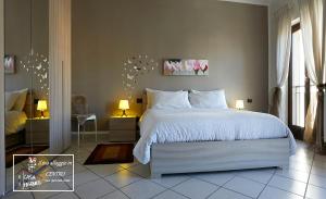 韋爾賈泰的住宿－Casa Pasquee，一间卧室配有一张带两盏灯的大型白色床。
