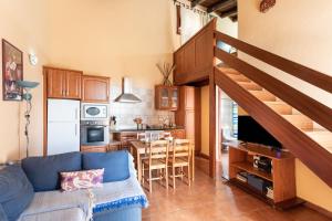 sala de estar con sofá azul y cocina en Home2Book Charming Rustic House El Pinar & Wifi, en El Pinar de El Hierro
