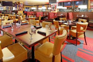 a restaurant with tables and chairs and a bar at Holiday Inn Arlington Northeast, an IHG Hotel in Arlington