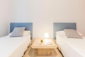two beds in a room with a table between them at GLP ALTEA DREAMS in Altea