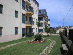 un immeuble d'appartements avec un jardin en face dans l'établissement Apartamento Playa Catedrales, à Barreiros