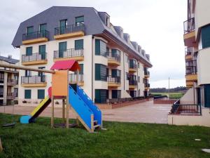 um parque infantil em frente a um edifício de apartamentos em Apartamento Playa Catedrales em Barreiros