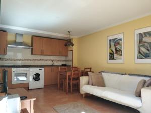 a living room with a white couch and a kitchen at Apartamento Playa Catedrales in Barreiros