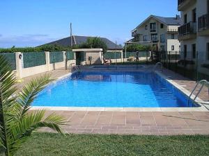 a large blue swimming pool next to a building at Apartamento Playa Catedrales in Barreiros
