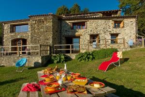 una mesa con comida frente a una casa de piedra en El Casal, en Prats-de-Mollo-la-Preste