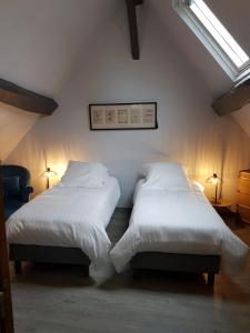 two beds in a room with white sheets and pillows at L'havre de Saint Germain in Saint-Germain-sur-Avre