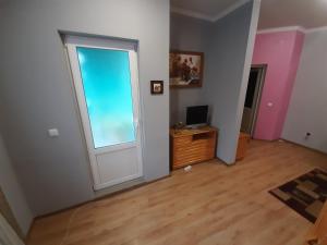 ein leeres Zimmer mit einer Tür und einem Schreibtisch mit einem Computer in der Unterkunft Лагуна in Snyatyn