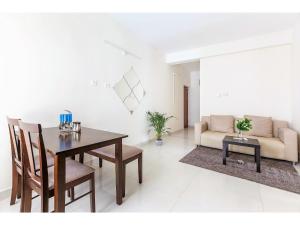 a living room with a table and a couch at Olive Service Apartments Hitech City in Hyderabad