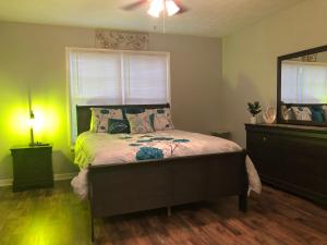 a bedroom with a bed and a dresser and a mirror at True-Mates Stay 5 minutes from Fort Bragg in Fayetteville