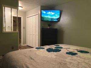 a bedroom with a bed with a television on the wall at True-Mates Stay 5 minutes from Fort Bragg in Fayetteville