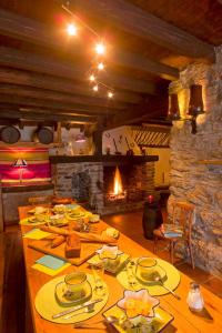 a long wooden table in a room with a fireplace at El Casal in Prats-de-Mollo-la-Preste