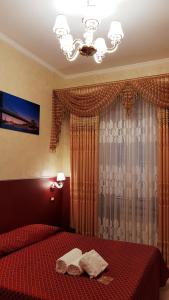 sypialnia z czerwonym łóżkiem i żyrandolem w obiekcie Vertex Palace w Rzymie