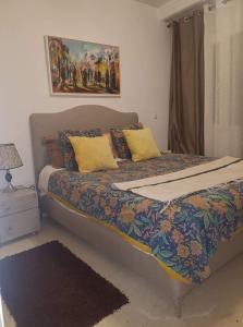 a bedroom with a large bed with yellow pillows at Agreable Appartement Ennasr 2 in Ariana