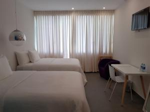 a hotel room with two beds and a table at Kaleo Hotel Boutique in San Salvador