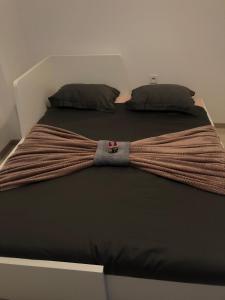 a bed with a brown tie on top of it at Studio Apartment New Home in Zagreb