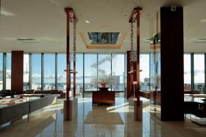 un vestíbulo con una habitación grande con ventanas de cristal en Candeo Hotels Omiya en Saitama