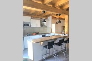 a kitchen with white cabinets and black bar stools at House Zemina in Lumbarda