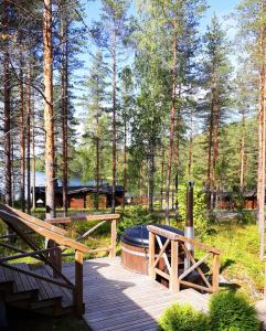 a wooden deck with a sauna and a fire place at Коттедж на берегу живописного озера in Kerimäki