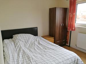 1 dormitorio con 1 cama, vestidor y ventana en A Double Bedroom Near Glasgow City Centre Not in Great Condition Suitable for Short Stay en Glasgow