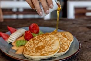 a plate of pancakes with fruit on it at Alma Tulum Hotel Boutique in Tulum